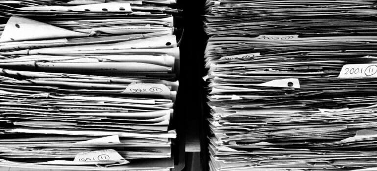 a stack of paperwork that you need to check before signing a moving contract