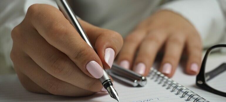A woman writing something in a notebook.