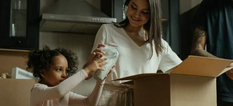 mother and daughter unpacking basic household items for first day in a new home