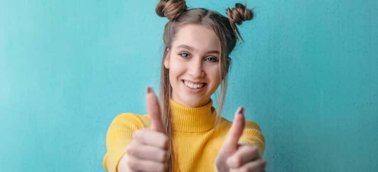 Girl holding thumbs up and smiling