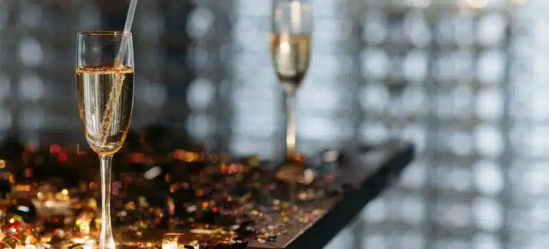 two glasses of liquor on a table filled with confetti