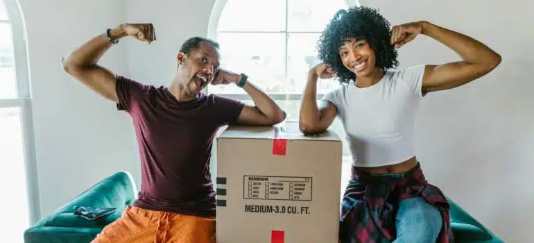 a woman flexing muscles with a mover inside her house