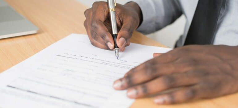 a man in a suit signing a contract on the table