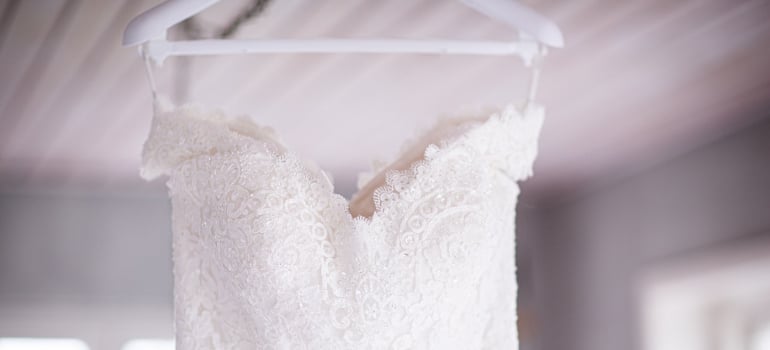 A wedding dress hanging on the hanger