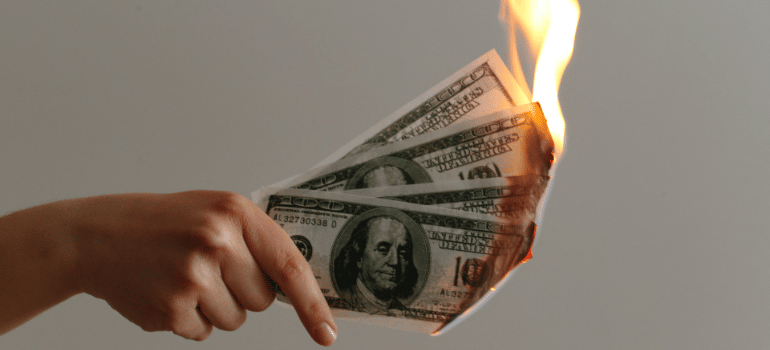 burning paper money in a hand