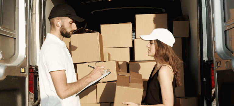 a man writing and a woman holding a box