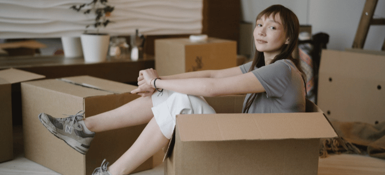 a woman sitting among boxes