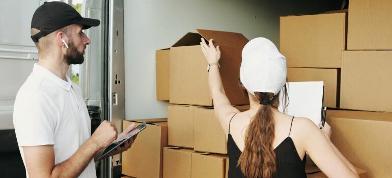A man and a woman checking boxes on moving day.