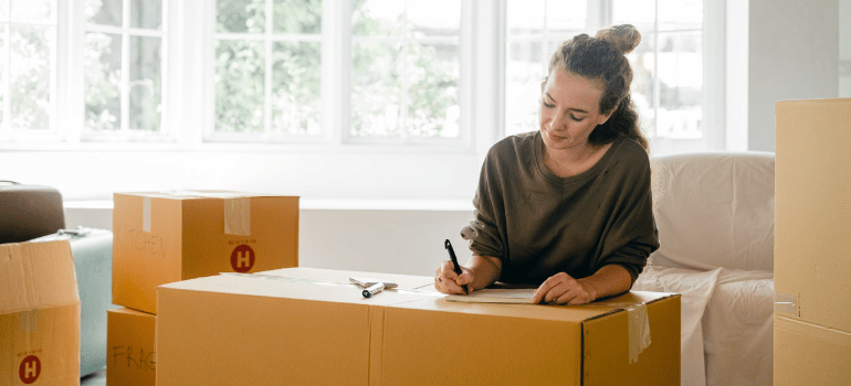a woman writing steps to moving out for the first time