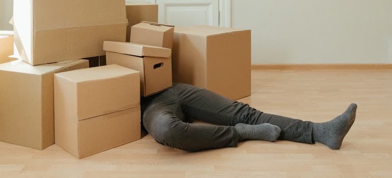 a man under a pile of boxes