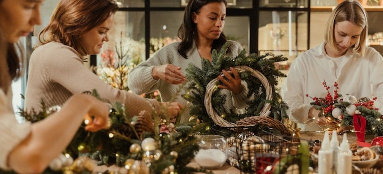Women making hanging wreaths together.