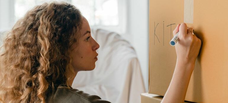 Woman labeling a cardboard box