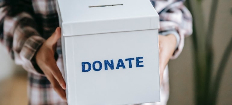 a person holding a box saying donate