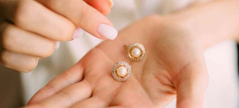 A person holding pearl earrings